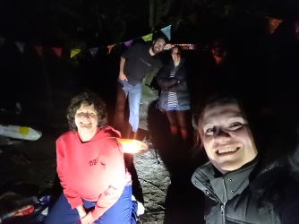 A group of people by torchlight, smiling